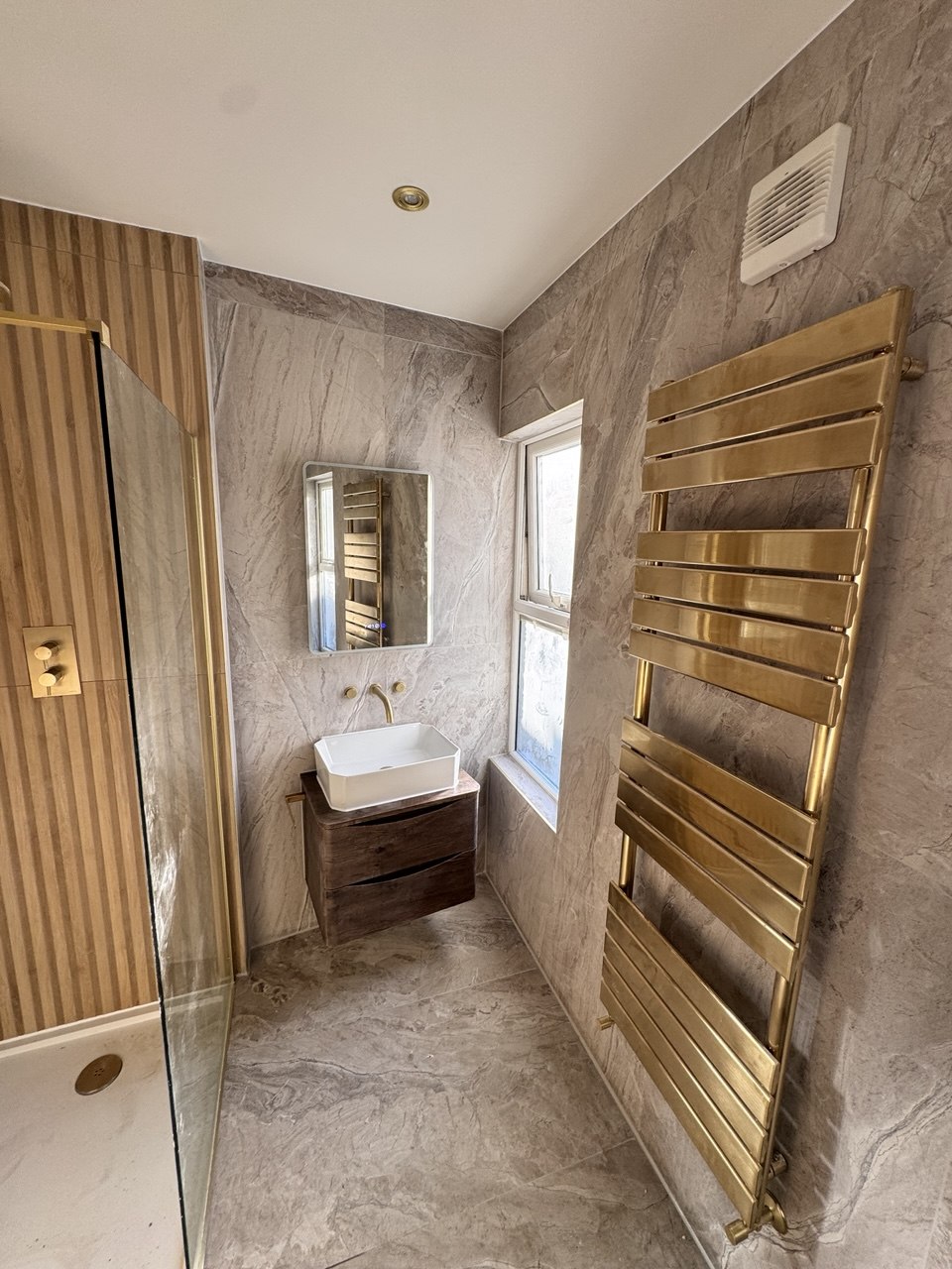 Full bathroom overview showing vanity, shower, and towel rail